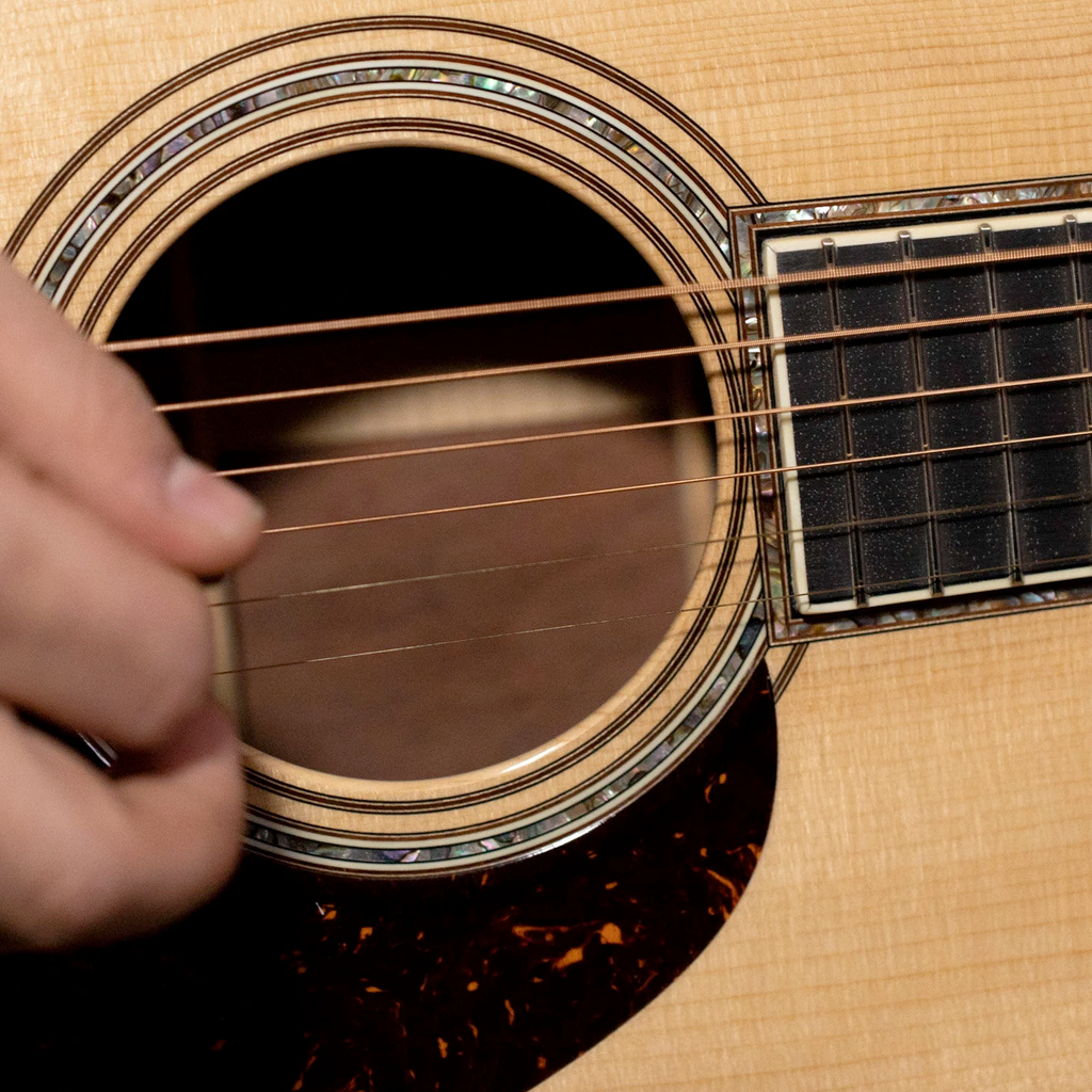 Close up of strumming guitar strings